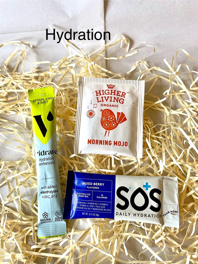 May include: A selection of hydration products, including a green and yellow "idrate" packet and a white packet with a bird design. A blue packet of "Mixed Berry" electrolyte drink mix and a white "SOS Daily Hydration" packet are also visible.