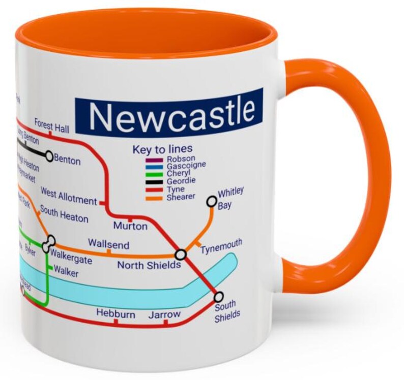 Puede incluir: Taza de cer&aacute;mica blanca con un mapa colorido del sistema de metro de Newcastle. La taza tiene un borde y un asa naranja. El mapa incluye los nombres de las estaciones y las diferentes l&iacute;neas. El texto "Newcastle" est&aacute; impreso en azul en la parte superior de la taza.