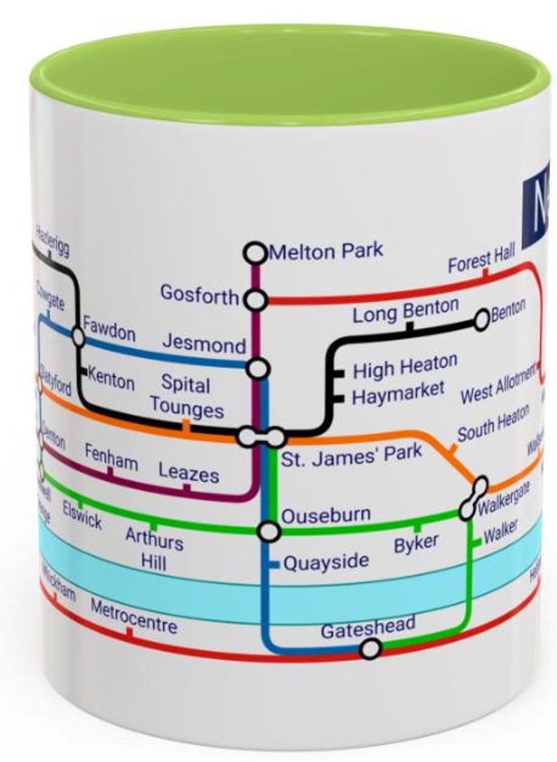 Puede incluir: Taza de cer&aacute;mica blanca con borde verde que presenta un mapa colorido del sistema de metro de Newcastle upon Tyne. El mapa incluye nombres de estaciones como Haymarket, Jesmond y Byker.