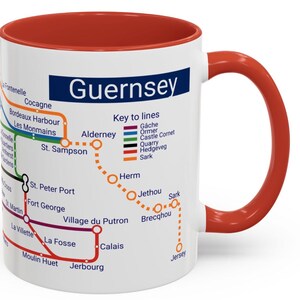 Puede incluir: Taza de cer&aacute;mica blanca con borde y asa rojos. La taza presenta un mapa de las Islas de Guernsey con el t&iacute;tulo "Guernsey" y una clave de l&iacute;neas con diferentes l&iacute;neas de colores que representan diferentes rutas. El mapa incluye los nombres de las islas y las ciudades.
