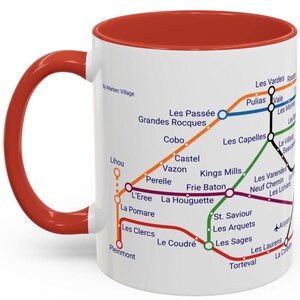 Puede incluir: Taza de cer&aacute;mica blanca con borde y asa rojos. La taza presenta un mapa del metro de Par&iacute;s con los nombres de las estaciones en franc&eacute;s.