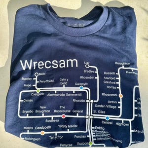 Könnte beinhalten: Ein marineblaues T-Shirt mit einer weißen Grafik einer Karte von Wrexham, Wales. Die Karte zeigt die Namen verschiedener Städte und Dörfer in der Gegend.