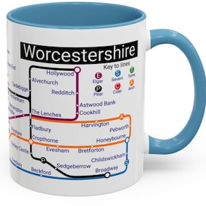 May include: White ceramic mug with a blue handle. The mug features a map of Worcestershire, England, with the names of towns and cities, and a key to the different lines. The text "Worcestershire" is printed in black at the top of the mug.