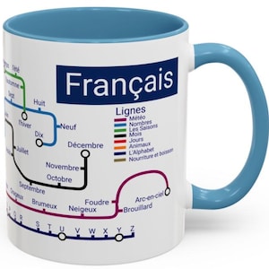 Peut inclure: Mug en céramique blanche avec intérieur et anse bleus. Le mug présente un design sur le thème français avec le mot "Français" dans un rectangle bleu. Le design comprend un diagramme coloré avec des mots français comme "Décembre" et "Juillet".