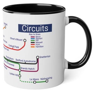 May include: White ceramic mug with a black rim and handle. The mug features a graphic of a race track map with the title "Circuits" and a key to lines with different colors representing different race tracks. The race tracks listed on the map include: Winfield, Oliver's Mount, Cadwell Park, Rockingham, Bedford Autodrome, Brands Hatch, Lydden Hill, Snetterton, Le Mans, and Nürburgring.