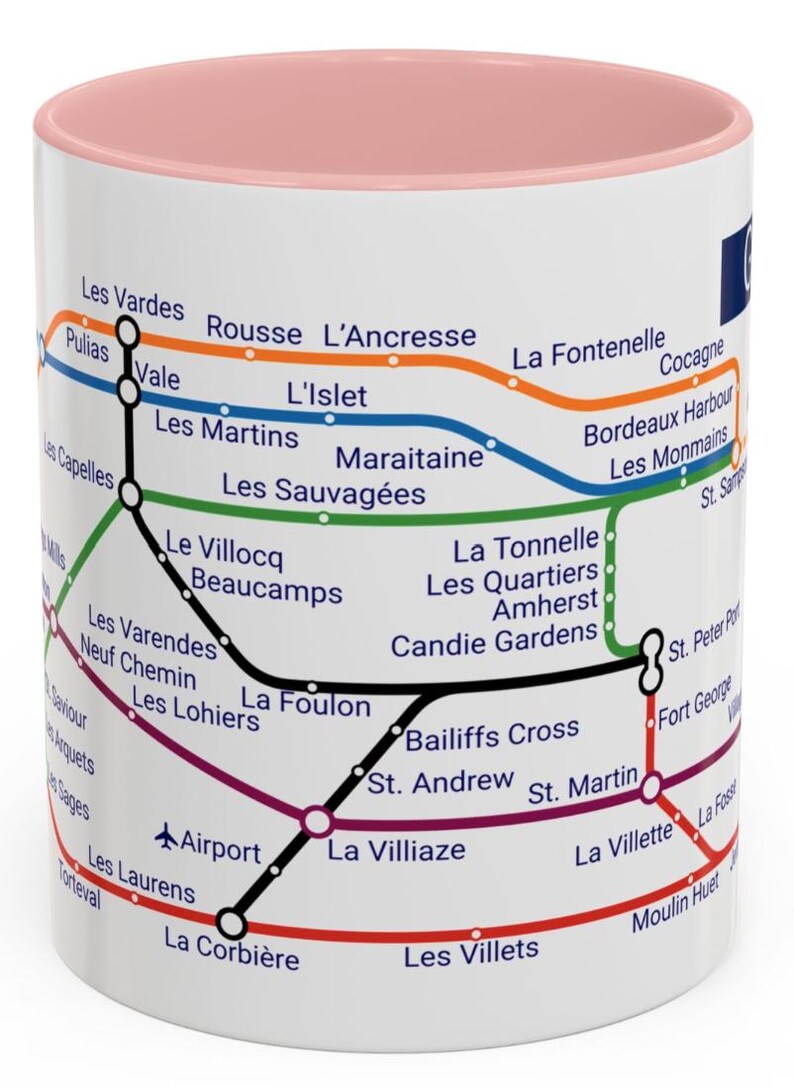 Puede incluir: Una taza de cer&aacute;mica blanca con un borde rosa presenta un mapa estilizado del sistema de metro de Montreal. El mapa incluye los nombres de las estaciones en franc&eacute;s, como "Les Vardes", "L'Islet" y "La Villiaze".