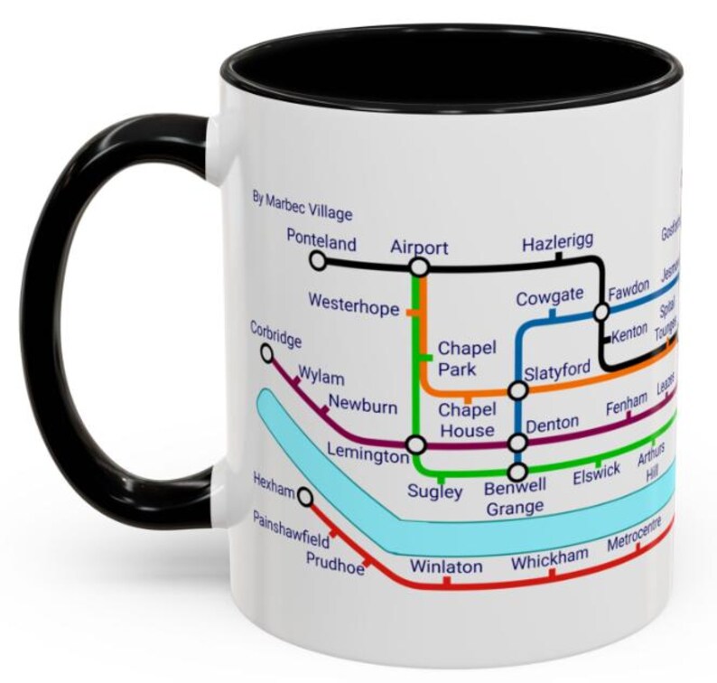 Puede incluir: Taza de cer&aacute;mica blanca con asa y borde negros. La taza presenta un mapa colorido del sistema de metro de Tyne and Wear en el Reino Unido. El mapa incluye nombres de estaciones como Airport, Westerhope y Metrocentre.