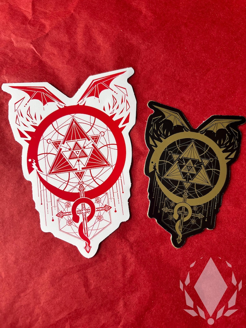 The Red sticker and Mirror Gold sticker are displayed on a red paper background. The Red sticker has a white background. The Mirror Gold sticker looks more matt here as it has less light. Icewreath's shop logo is placed in the corner.