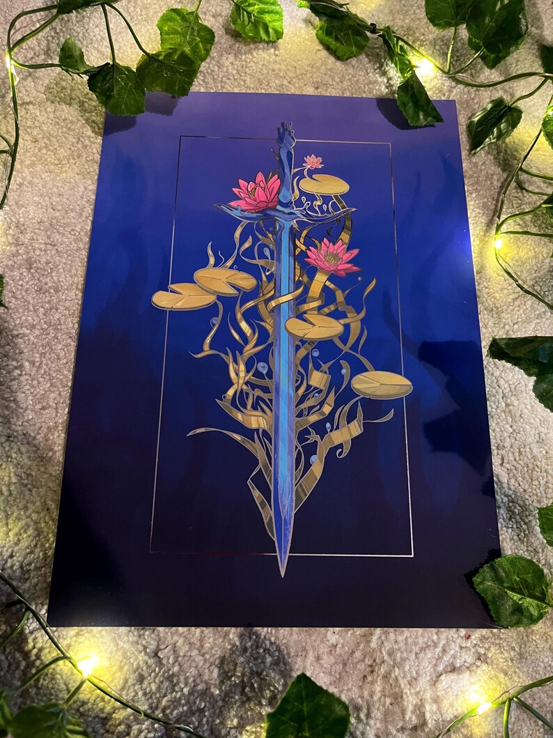 May include: A blue sword with a gold hilt is surrounded by gold vines and pink water lilies on a dark blue background.