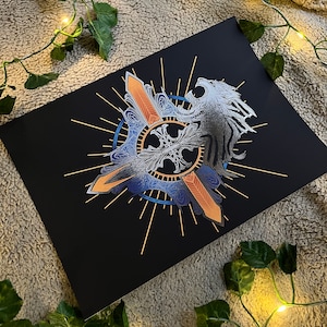 May include: A black and gold print featuring a stylized lion with wings and a sword design. The lion is surrounded by a circle of gold rays and a blue and gold design.