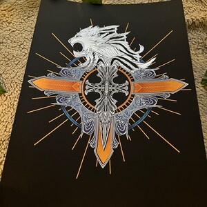 May include: A black and white print of a stylized lion's head with a cross and a sunburst design. The lion's head is white, the cross is gold, and the sunburst is orange.