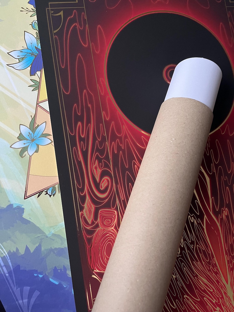 May include: A rolled-up poster with a black circle in the center surrounded by red and gold swirling designs. The poster is being held in a brown cardboard tube.