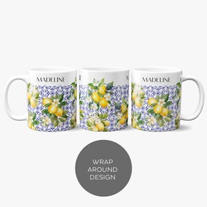 Puede incluir: Taza de cer&aacute;mica blanca con un dise&ntilde;o envolvente que presenta un limonero con limones amarillos y flores blancas sobre un fondo de azulejos azules y blancos. La taza tiene el nombre "MADELINE" impreso en la parte delantera.