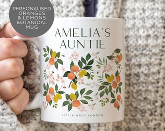 May include: White ceramic mug with a floral design featuring oranges, lemons, and bees. The mug has the text "Amelia's Auntie" and "Little Grey London" printed on it.