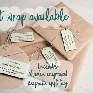 Puede incluir: Papel de regalo disponible con una etiqueta de regalo de madera grabada. La etiqueta es de color marr&oacute;n claro con texto blanco que dice "To Joe & Esme, Congratulations! Love & hugs from everyone at Oak House".