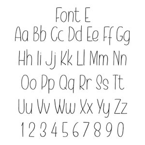 May include: A handwritten font alphabet in black ink on a white background. The alphabet includes uppercase letters, lowercase letters, and numbers 1 through 0.