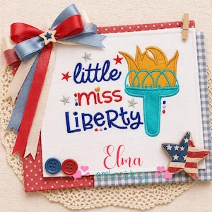 以下が含まれることがあります： 「little miss Liberty」の文字とトーチのイラストが描かれた愛国的なデザイン。赤、白、青の色使い、星型のリボン、星型の装飾にアメリカ国旗が描かれています。