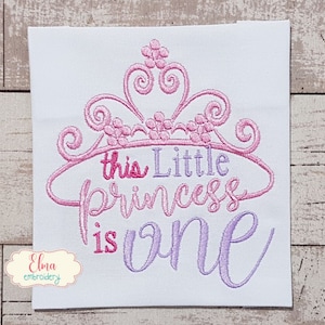 May include: Pink and purple embroidered design with a crown and the text "This little princess is one".