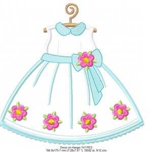 May include: A blue and white dress with a pink flower and bow on a hanger. The dress has a scalloped hem and is decorated with pink flowers.