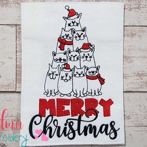 May include: White rectangular Christmas-themed embroidered design. It features a stack of cartoon cats wearing Santa hats and scarves, forming a Christmas tree shape. The words "MERRY Christmas" are embroidered in red and black.