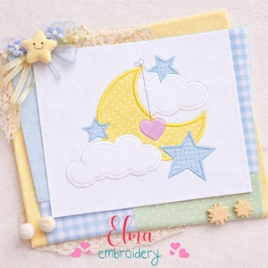 Può includere: Quadrato ricamato con una luna gialla a pois, stelle blu e nuvole bianche. Un cuore rosa pende dalla luna. Il disegno è su sfondo bianco, con il testo "Elma embroidery" in rosa.