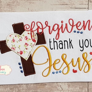 Puede incluir: Diseño bordado con una cruz marrón con un corazón floral y el texto "forgiven... thank you Jesus".