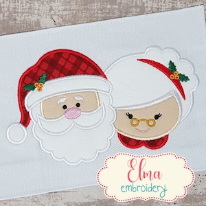 Puede incluir: Diseño bordado de Santa Claus y la señora Claus con gorros rojos y blancos y detalles de acebo. El diseño está sobre un fondo blanco.