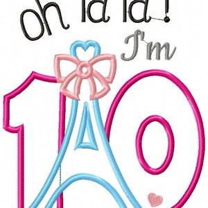 K&ouml;nnte beinhalten: Ein Stickdesign mit dem Text "oh la la! I'm" in Schwarz und Grau. Die Zahl 10 ist mit einer pinken Ziffer 1 und einer pinken Ziffer 0 stilisiert. Eine hellblaue Eiffelturmform befindet sich zwischen den Ziffern, gekr&ouml;nt von einer pinken Schleife.