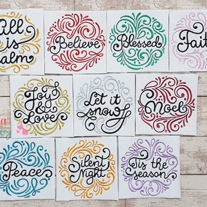 May include: A collection of embroidered patches with inspirational words and phrases. Each patch features a circular design with swirling embellishments and text such as "All is Calm", "Believe", "Blessed", "Faith", "Joy & Love", "Let it Snow", "Noel", "Peace", "Silent Night", and "Tis the Season".