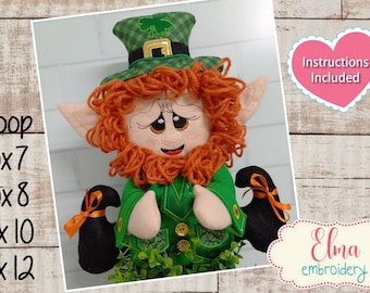 May include: Embroidered plush leprechaun doll with a green hat, orange hair, and black shoes. The doll is holding its hands together in a praying position. The doll is 5x7, 5x8, 6x10, or 7x12 inches. Instructions are included.