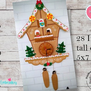 May include: A gingerbread house-shaped clock with a brown clock face, white numbers, and gold hands. The clock is decorated with candy canes, red and white dots, and a green wreath. The clock is 28 inches tall and fits in a 5x7 hoop. Instructions are included.