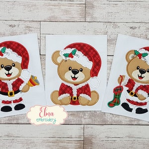 Puede incluir: Tres diseños bordados de un oso de peluche marrón vestido de Papá Noel. El primer diseño muestra al oso sosteniendo una campana, el segundo muestra al oso sentado y el tercero muestra al oso sosteniendo una media.