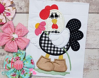 May include: Embroidered applique of a black and white checkered chicken holding a pink flower. The chicken has a red comb and white eyes. The chicken is wearing brown boots.