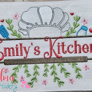 May include: Embroidered kitchen sign with the text "Emily's Kitchen" in red lettering. The sign features a chef's hat, a rolling pin, a jar, and floral accents.