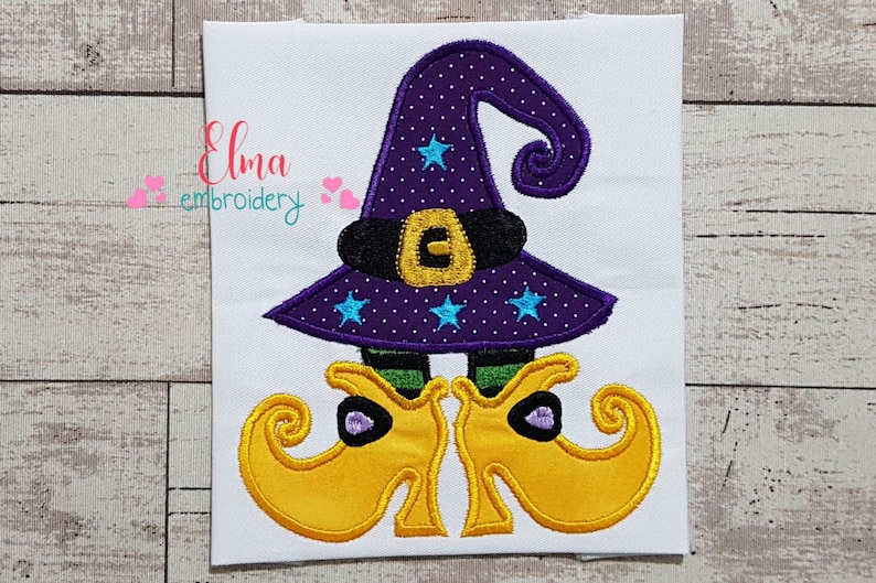 May include: Embroidered witch with a purple hat with stars and a black belt, and yellow shoes with curled toes.