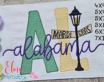 Op de afbeelding: Geborduurde afbeelding van de letters "AL" met het woord "alabama" in cursief daaronder. De "L" is versierd met een geel en gouden Mardi Gras-bord met de tekst "Mardi Gras". Naast het bord staat een zwarte lantaarnpaal met geel licht. Het ontwerp is verkrijgbaar in de maten 4x4, 5x4, 5x7, 5x8, 6x10 en 7x12 inch.