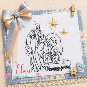 Op de afbeelding: Geborduurde kerststalscène met zwart garen op een witte vierkant, met Jozef, Maria en het kindje Jezus. De vierkant staat op een blauw-wit patroonachtergrond, met een decoratieve strik en houten versieringen.