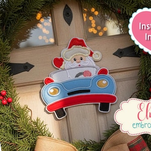 May include: An applique of Santa Claus in a blue and red car, with a white beard and red hat, is displayed on a door. The image includes text that says "Instructions Included" and "Elma embroidery". The applique is surrounded by a green wreath.