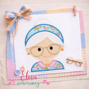 Puede incluir: Aplicaci&oacute;n de tela de una anciana sonriente con gafas, una diadema floral y un vestido floral azul. La imagen incluye un lazo, botones y el texto "Elma embroidery".
