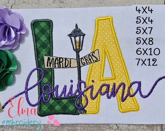 May include: Embroidered design of the letters "LA" with a green and yellow checkered pattern, a street sign that reads "Mardi Gras", and the word "Louisiana" in purple cursive. The design is available in sizes 4x4, 5x4, 5x7, 5x8, 6x10, and 7x12 inches.