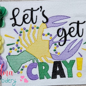 May include: Embroidered design featuring a purple and green crab with beads, a green and yellow trumpet, and the text "Let's get cray!" in black. The design is available in sizes 4x4, 5x5, 6x6, and 7x7 inches.
