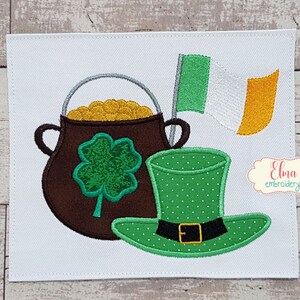 May include: Embroidered patch with a green leprechaun hat, a pot of gold, and an Irish flag. The pot of gold has a four-leaf clover on the side. The text "Elma embroidery" is in the bottom right corner.