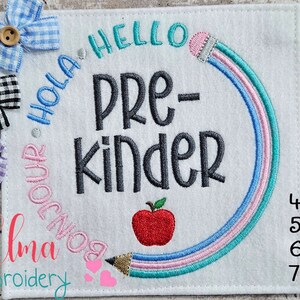 May include: Embroidered design featuring a rainbow pencil with the words "Hello", "Hola", "Bonjour", "Pre-kinder" and a red apple. The design is available in 4x4, 5x5, 6x6 and 7x7 inch sizes.