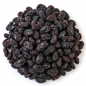 May include: A circular pile of dark purple, dried raisins with wrinkled, textured skins. The individual fruits are oval-shaped and clustered together in a dense, rounded arrangement, showcasing their deep, rich colour and dehydrated appearance.