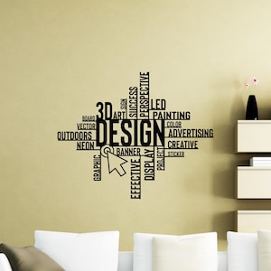 May include: A wall decal featuring the word "DESIGN" in large, bold letters, surrounded by related words like "CREATIVE," "ADVERTISING," and "GRAPHIC." A cursor graphic points towards the word "DESIGN." The decal is black against a beige wall.