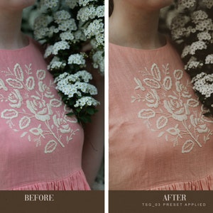 May include: A close-up of a pink linen dress with white embroidered flowers. The dress is worn by a person standing in front of a white flower bush.