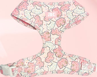 May include: A pink and white dog harness with a cookie pattern. The harness has a white buckle and a label that says "JBC".