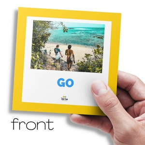 May include: A yellow card with a photo of two people walking on a beach with surfboards. The text "GO" is in blue letters on the card. The text "Take Time" is in smaller letters below the word "GO".