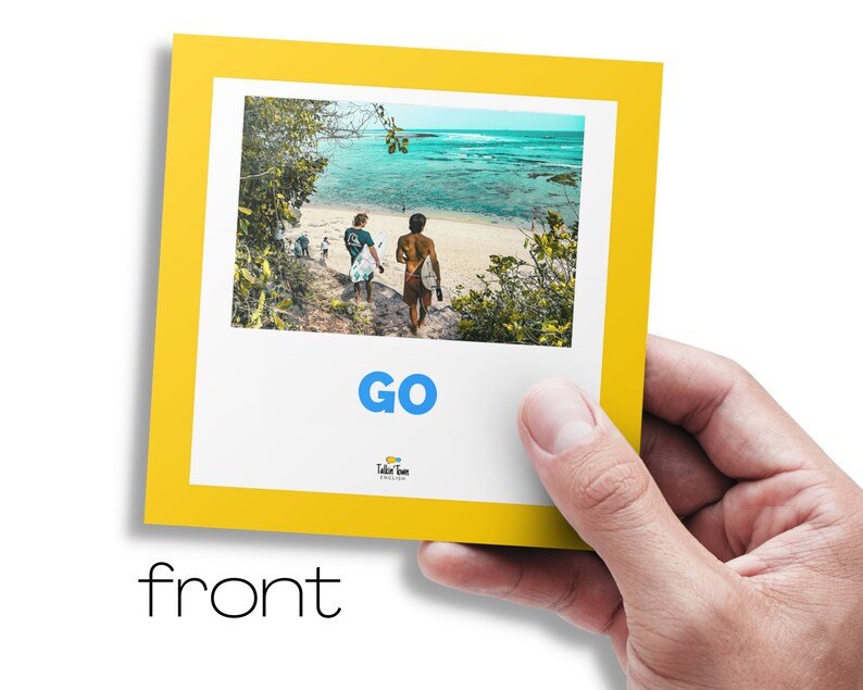 May include: A yellow card with a photo of two people walking on a beach with surfboards. The text "GO" is in blue letters on the card. The text "Take Time" is in smaller letters below the word "GO".