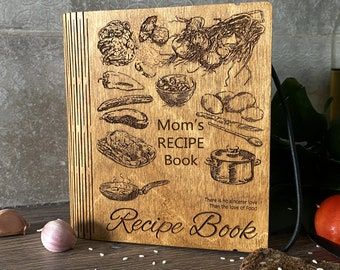 May include: A wooden recipe book with a brown wood cover and a laser-engraved design of food and the text "Mom's Recipe Book". The text "There is no sincerer love than the love of food" is also engraved on the cover.